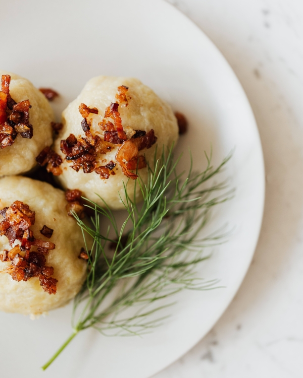 A dumpling covered with bacon and a garnish